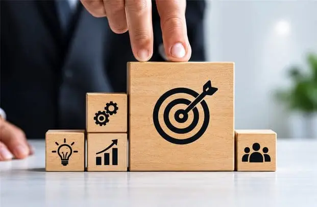 Wooden blocks with target and strategy icons being arranged